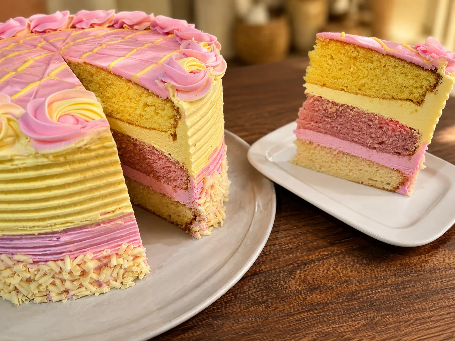 Pink and yellow layered gateau with a slice showing colourful layers at The Windy Ridge